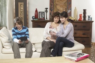 A family having fun with their Nintendo DSis. 